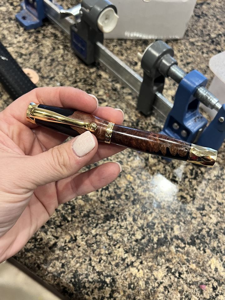 Pen made from burl wood and black resin with ornate gold hardware